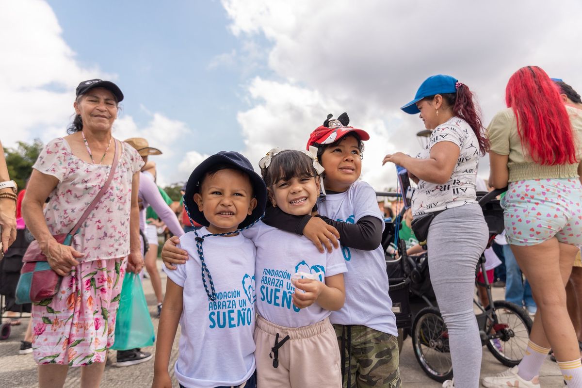 Tres niños sonríen juntos en el parque
