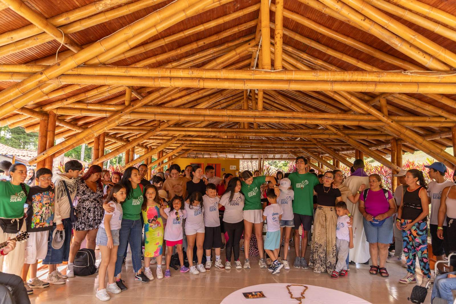 Niños, mamás y voluntarios del viaje Abraza Sueños Navideños 2025 reunidos bajo un kiosco de guadua