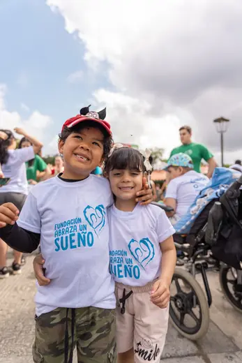 Dos niños sonríen abrazados en el Parque del Café