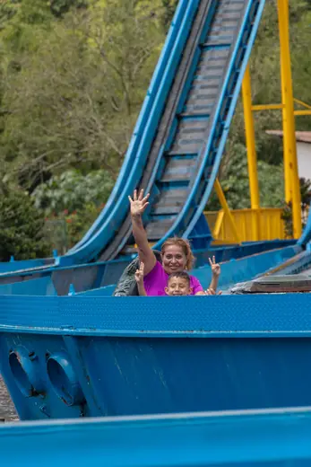 Una niña saluda desde el bote de la atracción del agua